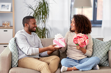 Image showing happy couple with flowers and gift at home