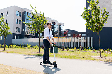 Image showing businessman with shopping bag riding scooter