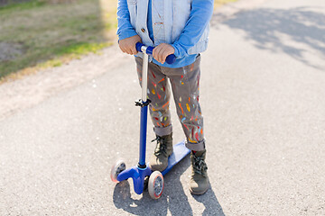 Image showing close up of little boy with scooter on road