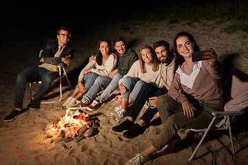 Image showing happy friends taking selfie at camp fire on beach