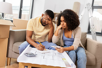 Image showing sad couple with blueprint counting money at home