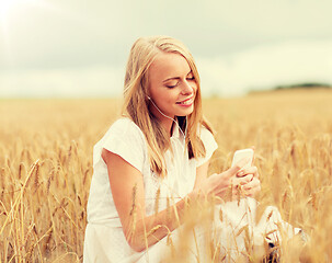 Image showing happy woman with smartphone and earphones