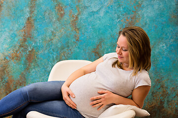 Image showing Young pregnant woman sitting on the armchair
