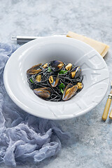 Image showing Black seafood spaghetti pasta with mussels over stone background. Mediterranean delicious food