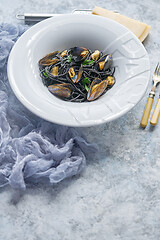 Image showing Black seafood spaghetti pasta with mussels over stone background. Mediterranean delicious food