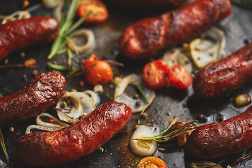 Image showing Delicious grilled sausages served on metal rusty tray. With barbecued vegetables