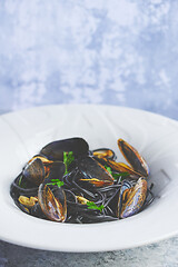 Image showing Black seafood spaghetti pasta with mussels over stone background. Mediterranean delicious food