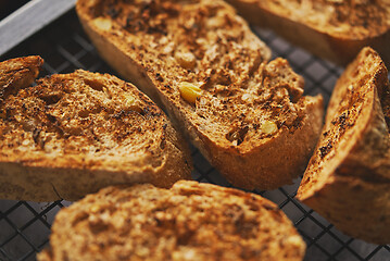 Image showing Close up marcor shot of toasted baguette slices placed on grill frame. Top view