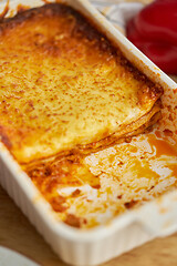 Image showing Meat lasagna with tomato sause and melted cheese in white baking dish