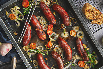 Image showing Delicious grilled sausages served on metal rusty tray. With barbecued vegetables