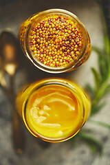 Image showing Two kinds of mustard. Frensh with whole seeds and honey served in glass jars