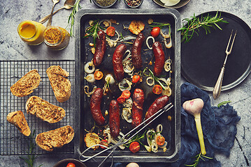 Image showing Delicious grilled sausages served on metal rusty tray. With barbecued vegetables