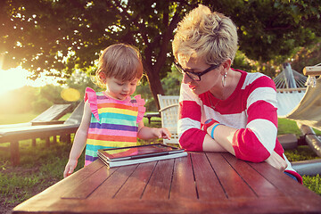 Image showing mom and her little daughter using tablet computer