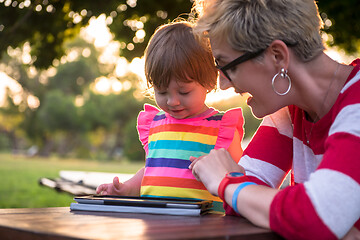 Image showing mom and her little daughter using tablet computer