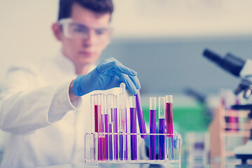 Image showing student with protective glasses making chemistry experiment