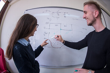 Image showing students writing on the white chalkboard