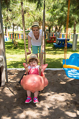 Image showing mother and daughter swinging in the park