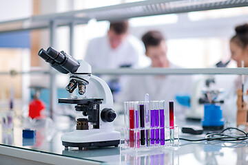 Image showing Microscope on the workplace near test tubes