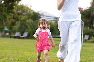 Image showing mother and little daughter playing at backyard