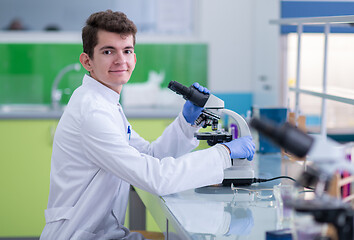 Image showing student scientist looking through a microscope