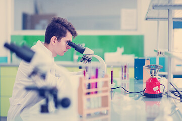 Image showing student scientist looking through a microscope