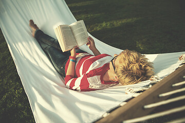 Image showing woman reading a book while relaxing on hammock