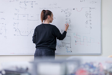 Image showing female student writing on board in classroom