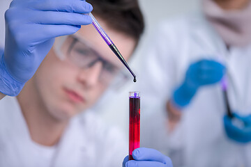 Image showing student with protective glasses making chemistry experiment