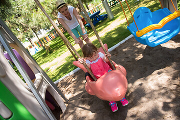 Image showing mother and daughter swinging in the park