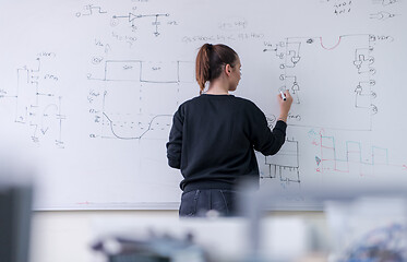 Image showing female student writing on board in classroom