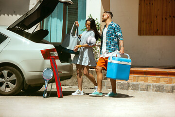 Image showing Young couple preparing for vacation trip on the car in sunny day