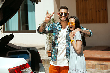 Image showing Young couple preparing for vacation trip on the car in sunny day