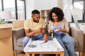 Image showing couple with blueprint counting money at home