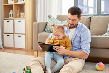 Image showing father and baby daughter with tablet pc at home