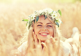 Image showing happy woman in wreath of flowers on cereal field