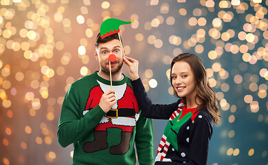 Image showing couple with christmas party props in ugly sweaters