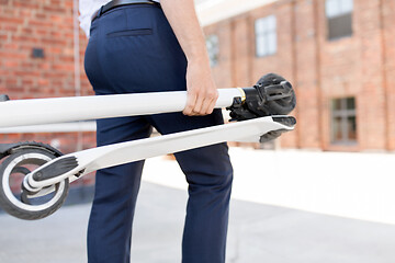 Image showing businessman with folding scooter in city