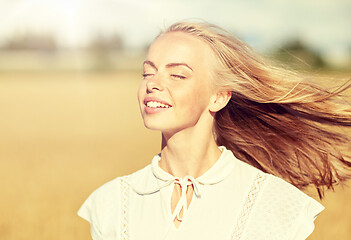 Image showing smiling young woman in white on cereal field