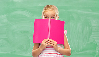 Image showing little girl hiding over book at school