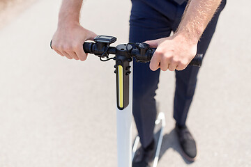 Image showing young businessman riding electric scooter outdoors