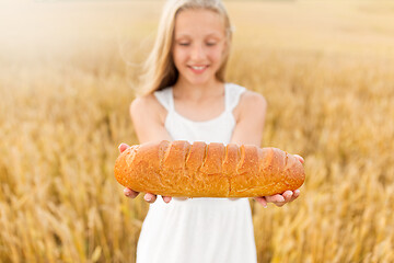 Image showing girl with loaf of white bread on cereal field