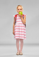 Image showing little school girl eating green apple