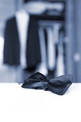 Image showing Bow tie. Open closet and tuxedo.