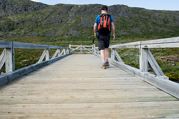 Image showing Man walking over bridge