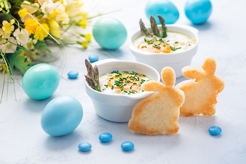 Image showing Shirred eggs (Oeuf cocotte) or baked eggs with green asparagus with Easter bunny and eggs