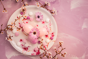 Image showing Pink Easter eggs with blooming branch and sweets for Easter and spring