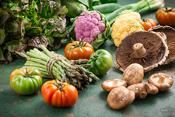 Image showing Assortment of organic vegetables and edible mushrooms on green background