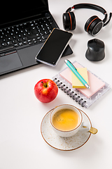 Image showing Working place and office desk with coffee, apple, laptop, headset and smarthpone