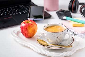 Image showing Working place and office desk with coffee, apple, laptop, headset and smarthpone