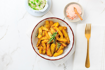 Image showing Homemade baked potato wedges with garlic dip